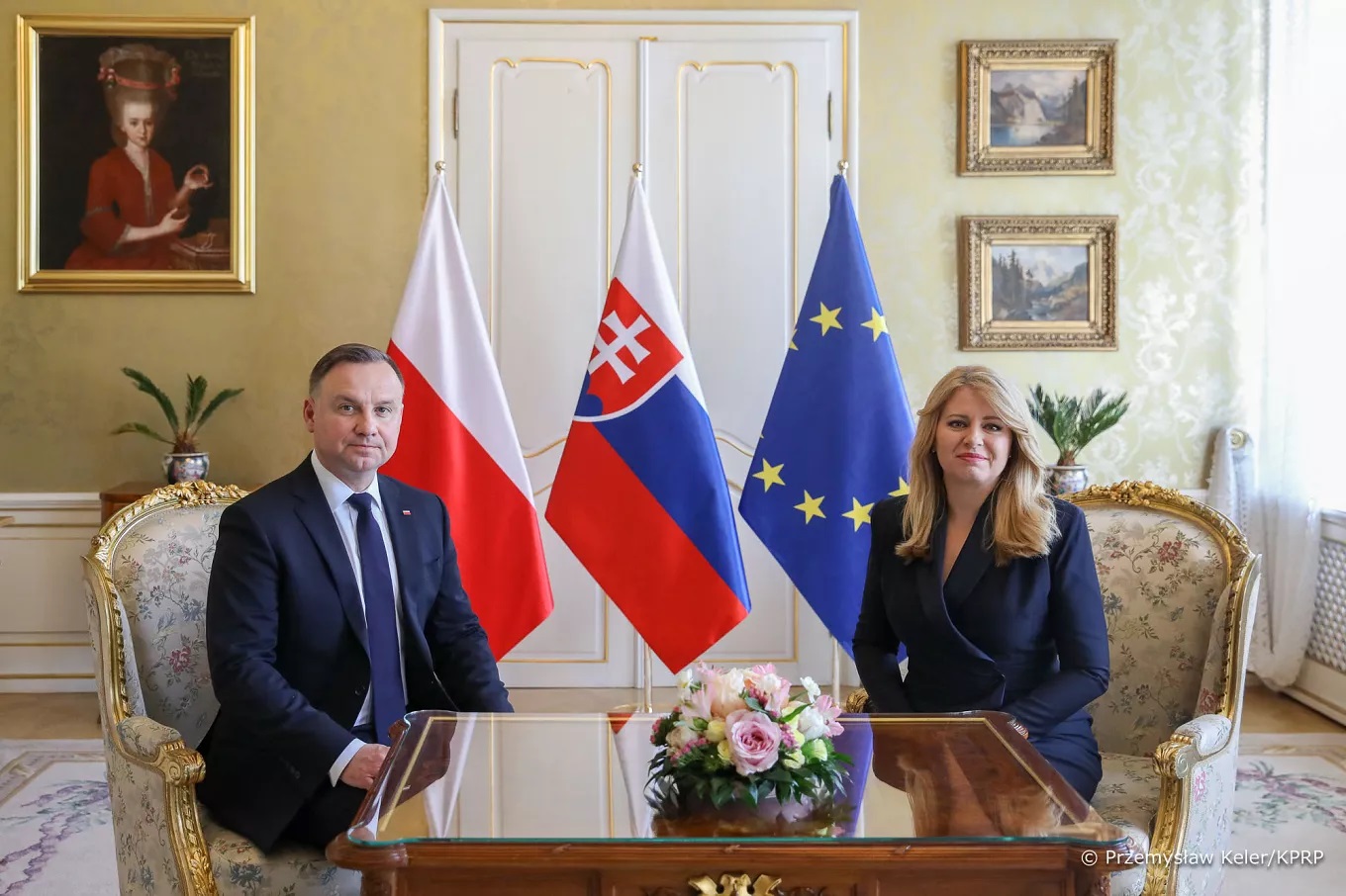 rezydenci Polski i Słowacji Andrzej Duda i Zuzana Čaputová na tle flag narodowych.